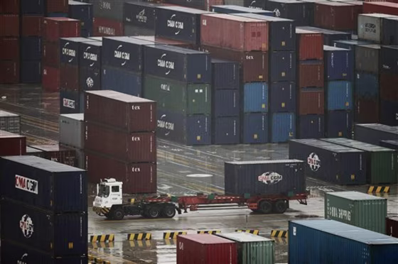 In this March 5, 2010 file photo, a tractor truck transports one of shipping containers at Yangshan deep-water port in Shanghai, China. China has&nbsp;called on Washington to cool its "politicization and emotionalization" of the trade issue.